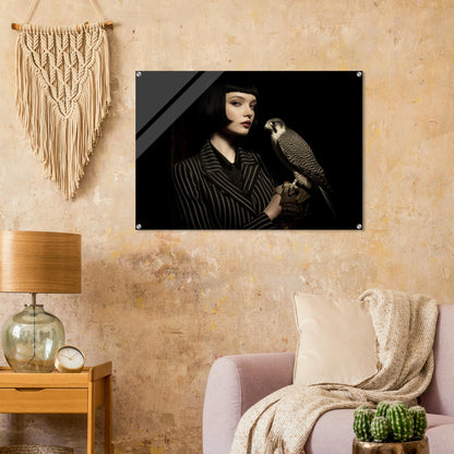 elegantes frauenportrait mit falke in dunkler bildsprache im wohnzimmer