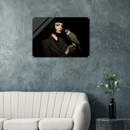 elegantes frauenportrait mit falke in dunkler bildsprache im wohnzimmer